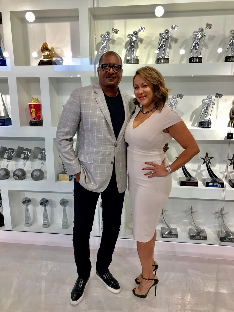 Heather Beverly, Esq. with a client in front of an awards display